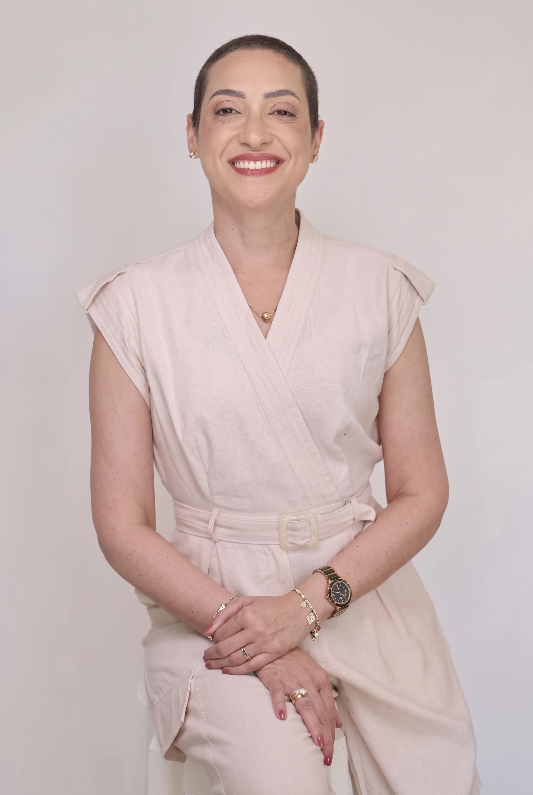 Patrícia Cronemberger sorrindo, vestido bege claro, em pé